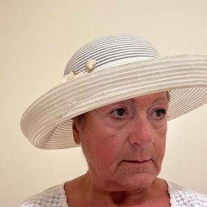 Off white wide brim hat with satin band & silk flowers accent.